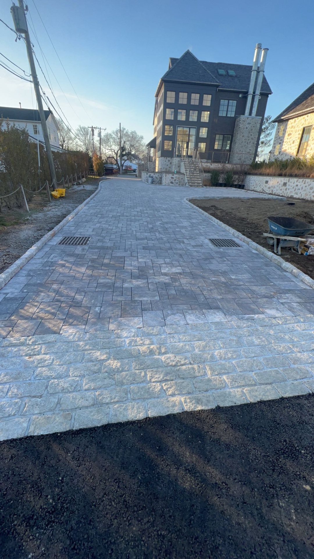Paver driveway with cobble border leading to a modern home