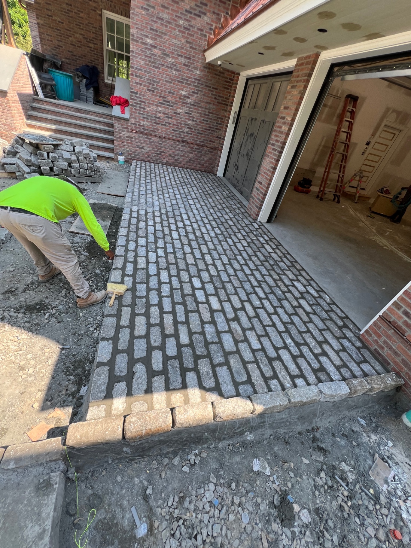 Cobblestone garage apron next to a brick building