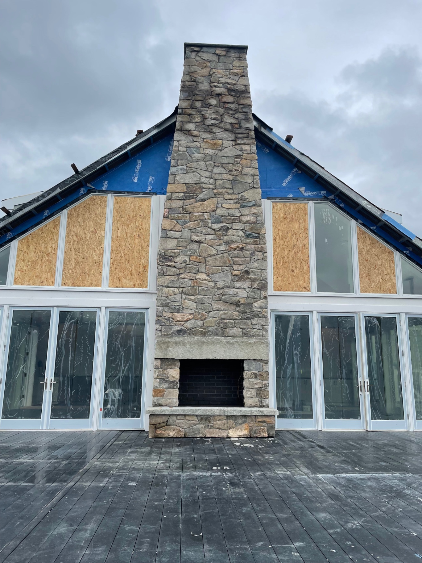 Two-story exterior stone chimney and fireplace