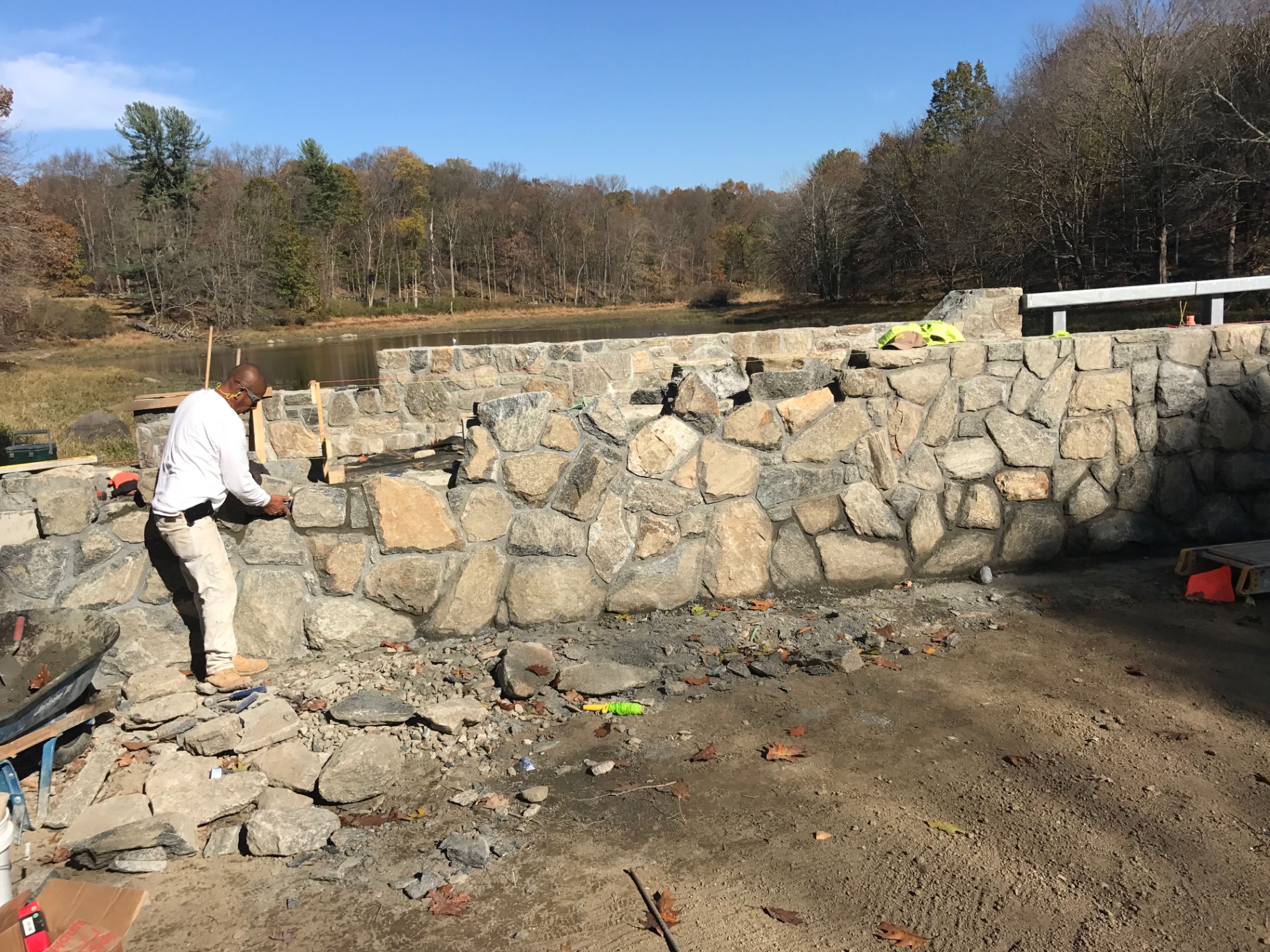 Mason building a lakeside fieldstone wall
